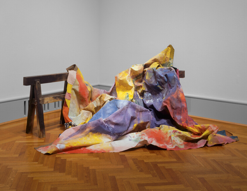 Sculpture made of orange, blue, red green, purple dyed canvas bunched and draped over an object by Sam Gilliam.